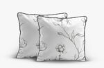 Two light gray decorative throw pillows with black floral line drawings and dark edging.