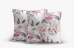 Two decorative square pillows with a pink and gray floral pattern on a white background with pink piping edges, arranged together on a surface.