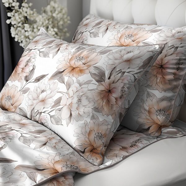 Floral-patterned bedding with peach and grey flowers on white, on a bed with a tufted headboard.