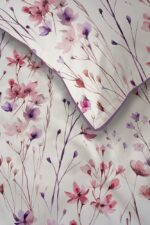 White fabric with pink and purple flowers and a purple edge, displaying a soft floral pattern.