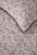 Soft pink wallpaper with small pink roses and gray vines, plus a folded corner with darker pink trim.