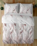 Top-down view of a white bed with a duvet and two pillows featuring pink and gray tall grasses and small butterflies.